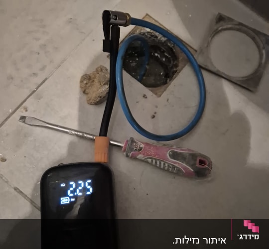 מד לחץ דיגיטלי, צינור כחול ומברג על רצפה